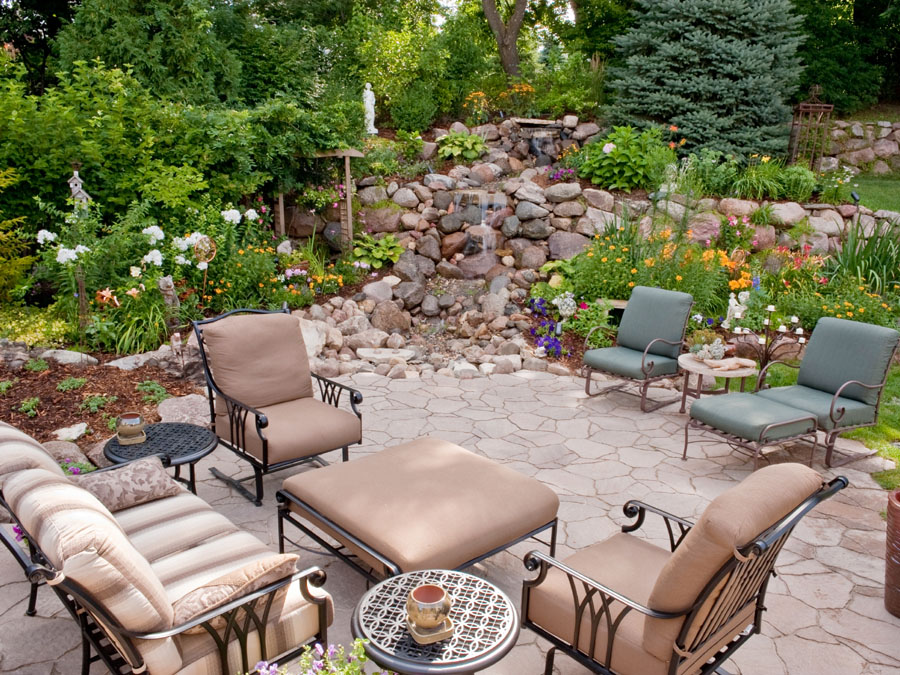 A garden patio with a pondless waterfall in the morning light.